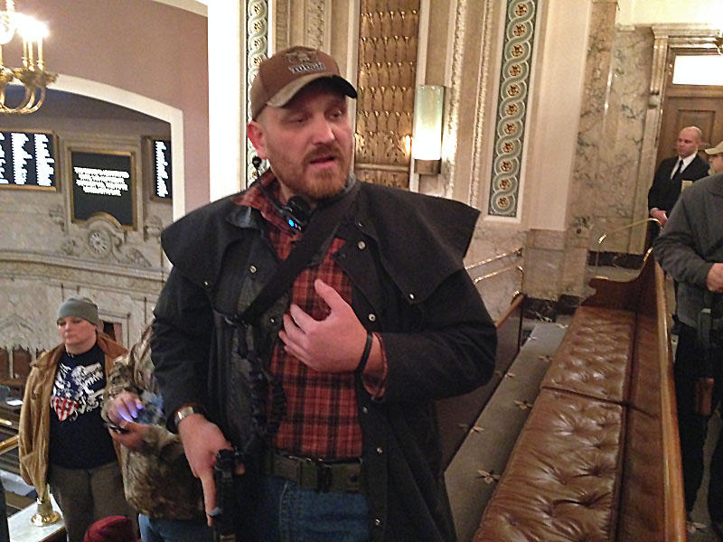 Jason McMillan carrying a military-style pistol in the Washington state House gallery in 2015. Beginning in January of 2018, all guns were banned from the state Senate gallery. | CREDIT: Austin Jenkins/N3