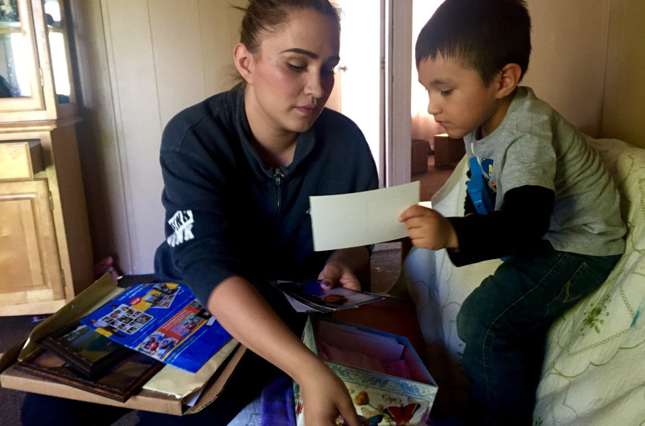 Sally Garcia Acosta shows her son Daniel, 3, photos of his sister. Maria Rosario Perez died from anencephaly, which is affecting three Eastern Washington counties at four times the national average CREDIT: COURTNEY FLATT