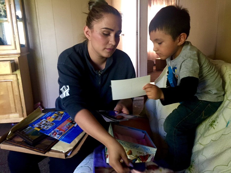 Sally Garcia Acosta shows her son Daniel, 3, photos of his sister. Maria Rosario Perez died from anencephaly, which is affecting three Eastern Washington counties at four times the national average CREDIT: COURTNEY FLATT