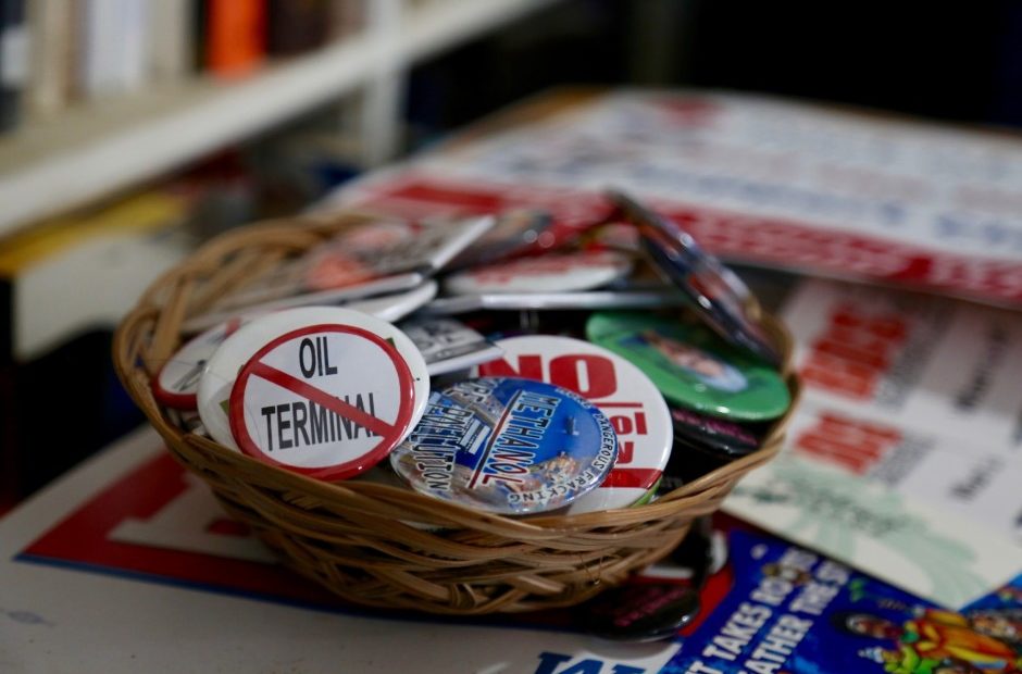 A bowl of buttons sit on top a pile of campaign signs against various fossil fuel projects in the Pacific Northwest. CREDIT: MOLLY SOLOMON