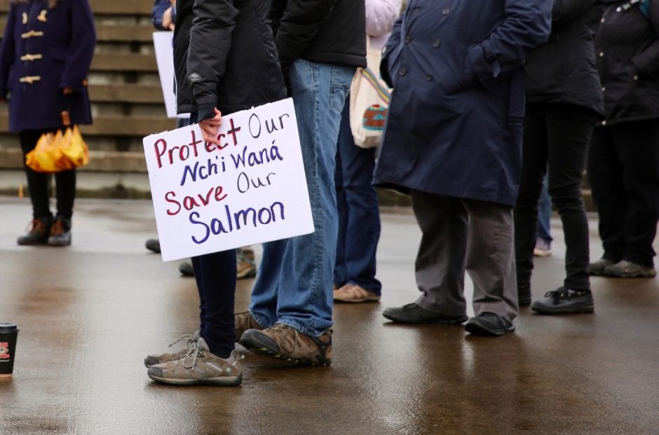 A protestor holds a sign at a rally at the Vancouver Landing Amphitheater along the Columbia River on Nov. 11, 2017 demanding accountability for pollution in the river. CREDIT: ERICKA CRUZ GUERVARRA