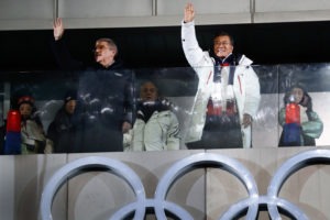 President of the International Olympic Committee Thomas Bach (left) and South Korea's President Moon Jae-in (center) wave during the opening ceremony. CREDIT: ODD ANDERSON/AFP/GETTY IMAGES