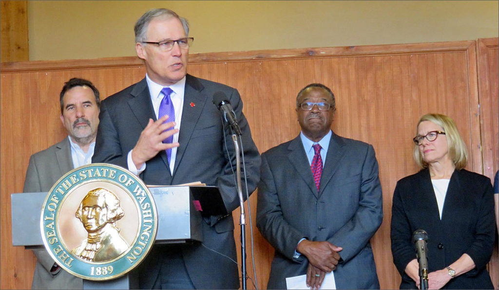 Gov. Jay Inslee launched a task force in Seattle Wednesday to save endangered orcas from extinction. The new panel's co-chairs, Les Purce and Stephanie Solien stand at right. Suquamish Tribal Chairman Leonard Forsman stands at left. CREDIT: TOM BANSE/N3