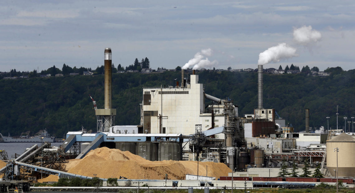 In this 2016, file photo, piles of wood chips sit near the RockTenn paper mill in Tacoma, Wash. Another ambitious effort to pass a carbon tax in Washington state has faltered as both Gov. Jay Inslee and the bill's prime sponsor conceded Thursday. CREDIT: TED S. WARREN, FILE / AP PHOTO