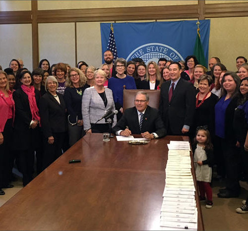 Washington Gov. Jay Inslee poses with state Sen. Karen Keiser at a bill signing ceremony on Wednesday.