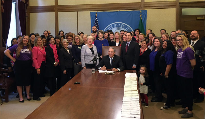 Washington Gov. Jay Inslee poses with state Sen. Karen Keiser at a bill signing ceremony on Wednesday.