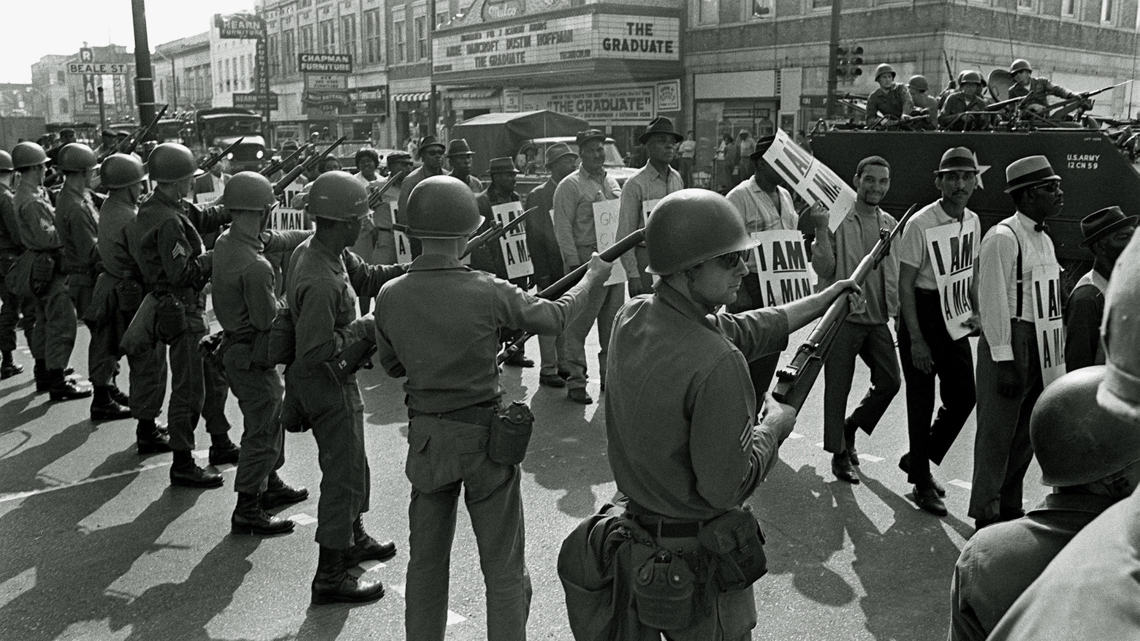 Striking sanitation workers and their supporters are flanked by bayonet-wielding National Guard troops and armored vehicles during a march on City Hall in Memphis, Tenn., on March 29, 1968, one day after a similar march erupted in violence, leaving one person dead and several injured. CREDIT: CHARLIE KELLY