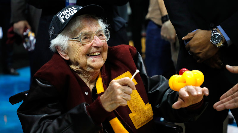 Sister Jean Dolores Schmidt celebrates with the Loyola men's basketball team. Sister Jean, 98, is the team's long-time chaplain, and holds a piece of the net after Loyola made it to the Final Four. CREDIT: KEVIN C. COX