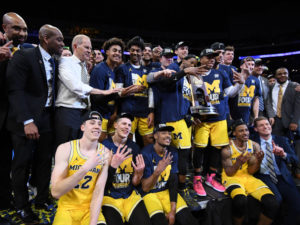 The Michigan Wolverines celebrates after defeating the Florida State Seminoles 58-54 at the Staples Center in Los Angeles, California on March 24. Coach John Beilein has led the team in 13 straight wins and now to the Final Four. CREDIT: HARRY HOW