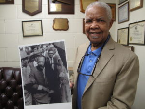 Fred Davis, a former Memphis city councilmember, holds a photograph taken on March 28, showing him standing near King with a crowd following behind. CREDIT: DEBBIE ELLIOT