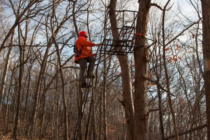Jacob Zeuske climbs into a deer stand overlooking a wooded basin in Sauk County, Wis. CREDIT: NATHAN ROTT