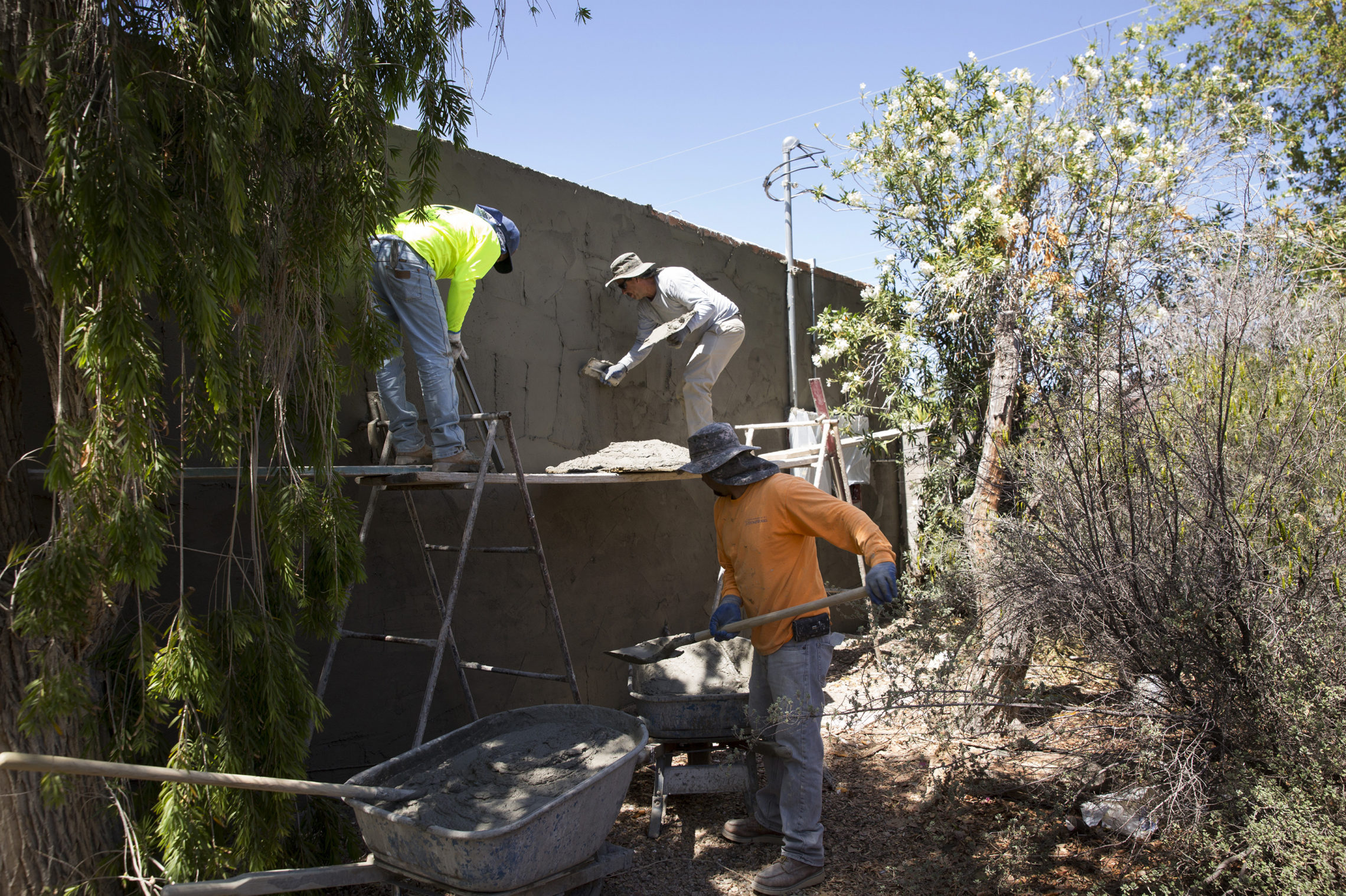 Contractors apply stucco to the exterior of a home being renovated by Rosin and Pickett. Ten years into her career flipping houses, Rosin's operation is much more streamlined and professional. Still, it's harder to make money. CREDIT: CAITLYN O'HARA