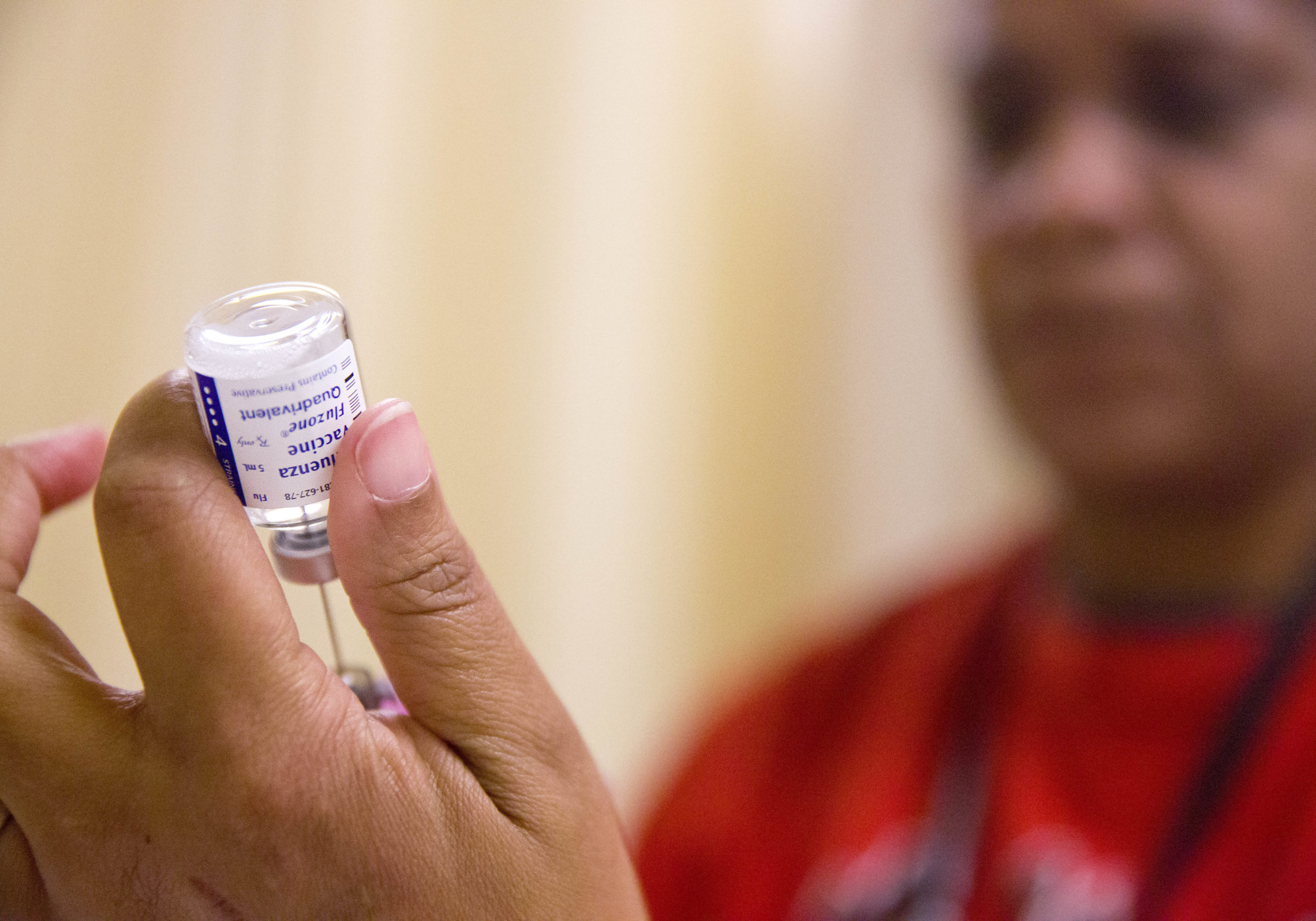 A nurse prepares a flu shot from a vaccine vial. CREDIT: DAVID GOLDMAN