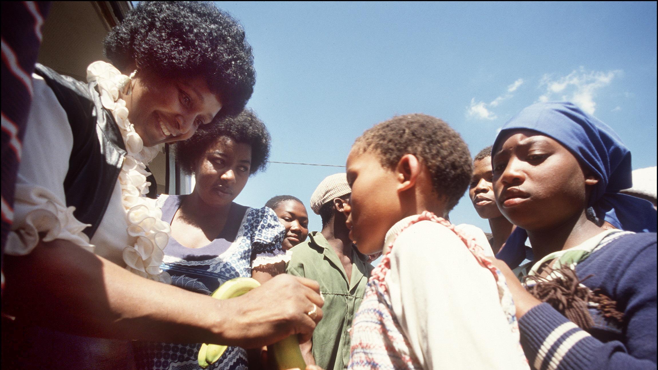 Winnie Madikizela-Mandela returns to the town of Brandfort, where she had been banished by the white government for nine years, to visit local children in 1986. CREDIT: GIDEON MENDEL