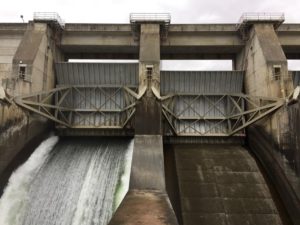 Water flows through an open spill bay at The Dalles Dam. CREDIT: CASSANDRA PROFITA