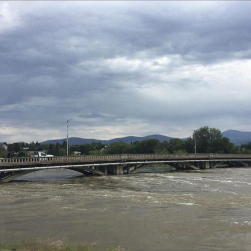 The flooded Okanogan River flowing through downtown Omak, Friday, May 18, 2018.