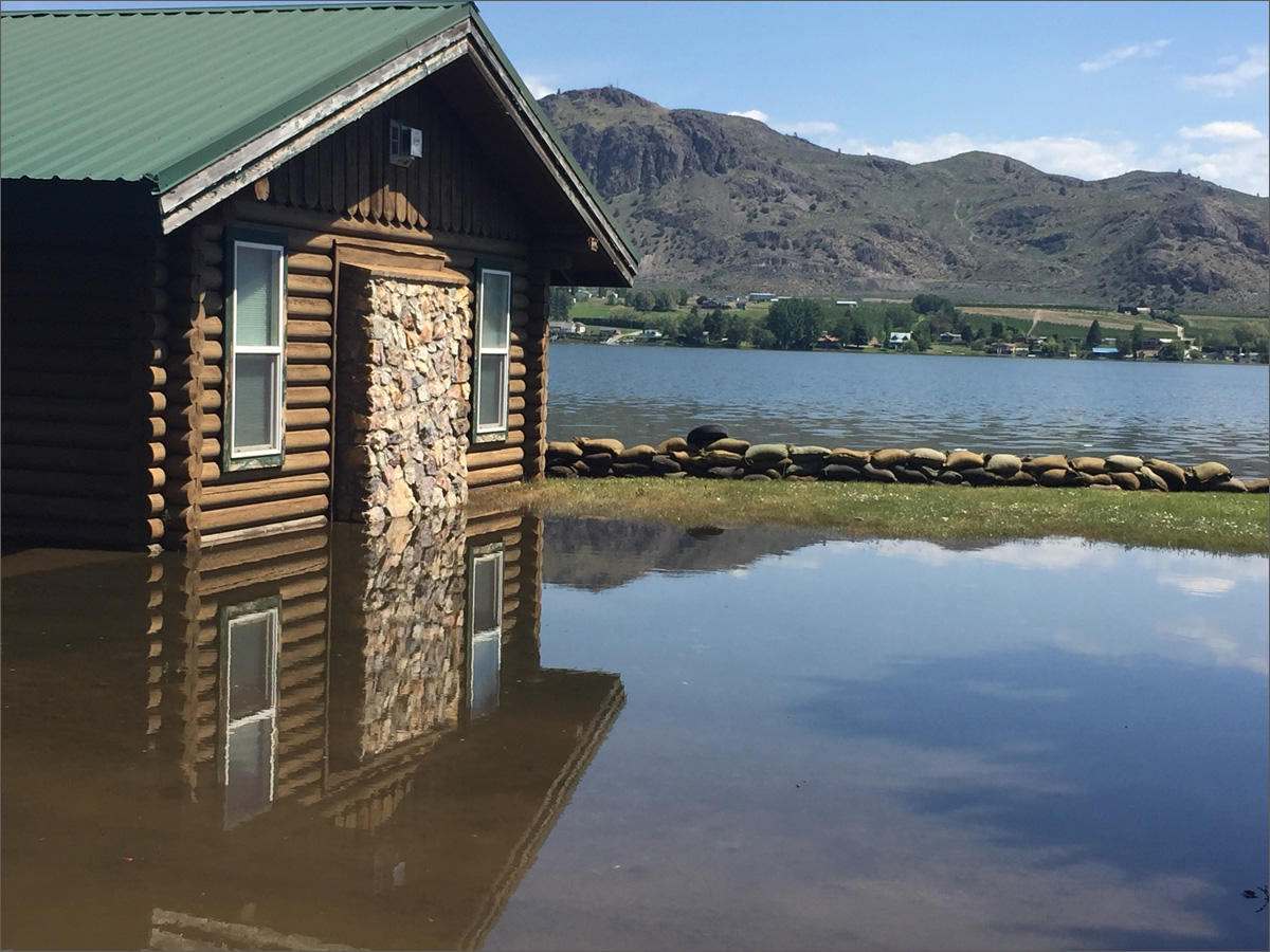 A home along Lake Osoyoos in Oroville, Washington, is already inundated with flood water. A near record snow year in southern British Columbia combined with temperatures in the upper 80s means flood waters will continue to rise. CREDIT: EMILY SCHWING/NORTHWEST NEWS NETWORK