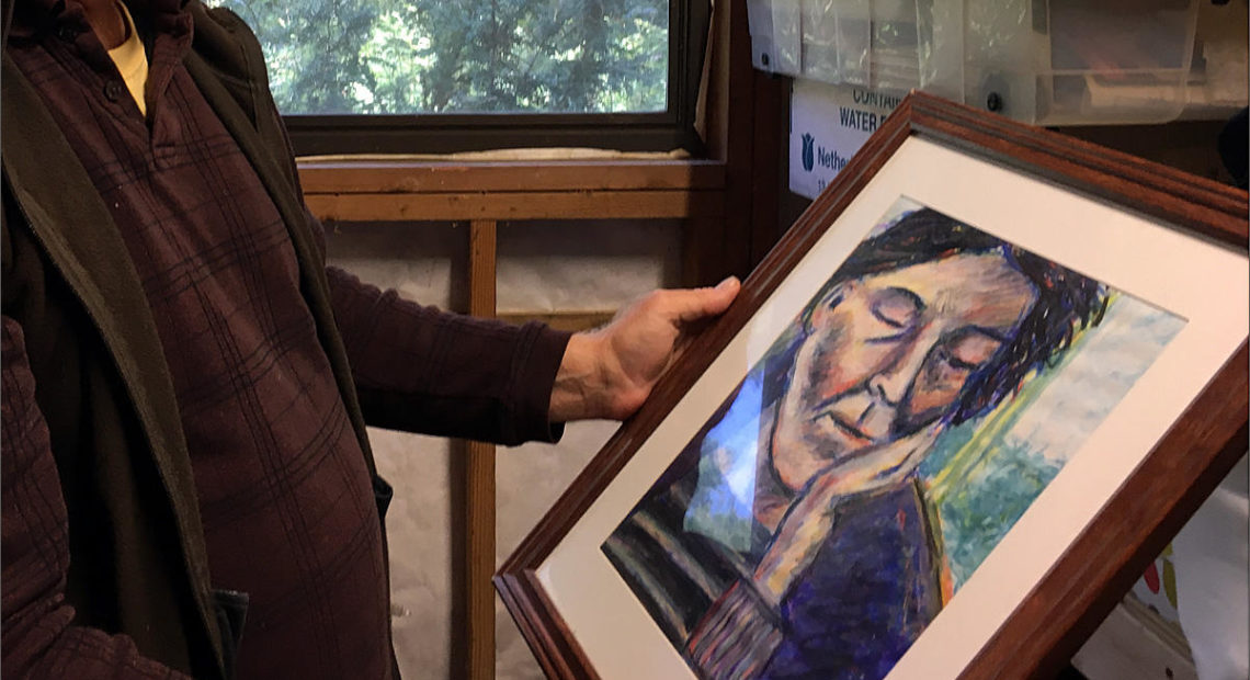 Brian (who asked us not to use his last name) holds a piece of artwork that his daughter made. He says she's struggled with mental illness since college and needs a safe, stable placement in the community. CREDIT: AUSTIN JENKINS