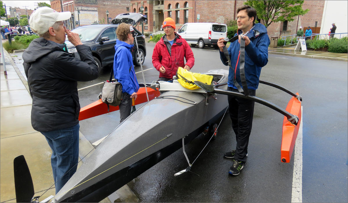 Matt Johnson, right, of Seattle plans to pedal all the way to Alaska in this 20-foot home-built boat. The pedal-driven propeller can be seen to the left of Johnson's feet. CREDIT: TOM BANSE