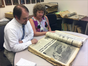 Brock Hires, managing editor of the Omak-Okanogan Chronicle, and Teresa Myers, the paper's publisher, look through photos and stories of flooding in 1972 in the newspaper's archives.