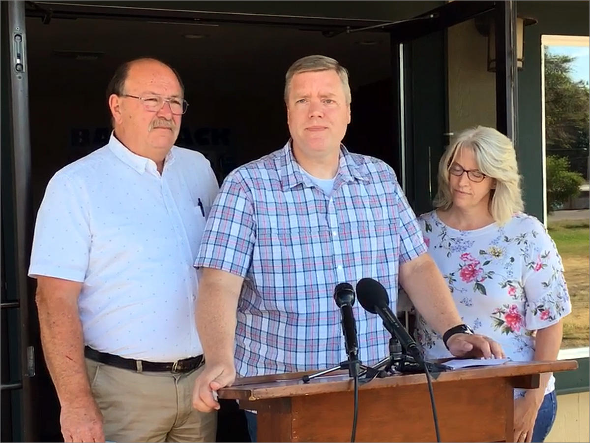 Pastor David George, flanked by his wife and the Oakville, Washington, fire chief, describes pulling his pistol and fatally shooting a gunman at the Tumwater Walmart on Father's Day. CREDIT: AUSTIN JENKINS/N3