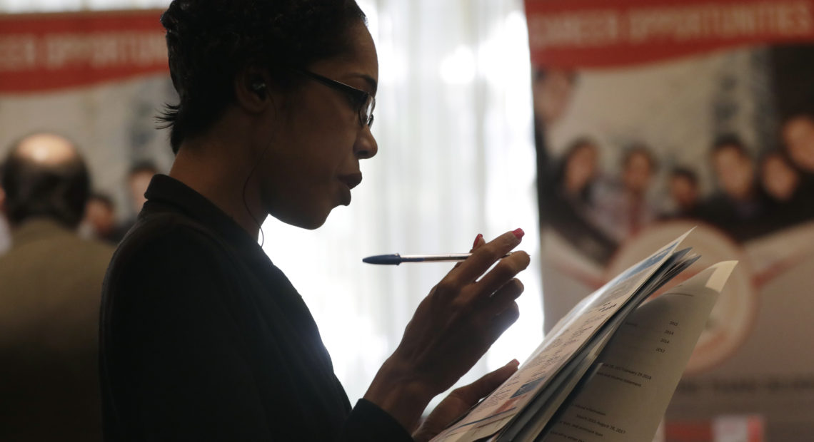 Joana Dudley looks at a list of job prospects at a job fair in Miami Lakes, Fla., in January. In the government's June jobs report, the unemployment rate ticked up to 4 percent with more people entering the labor force. CREDIT: Lynne Sladky/AP