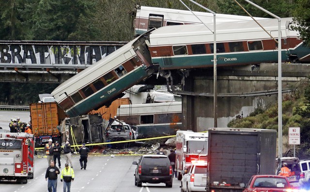 Cars from an Amtrak train lie spilled onto Interstate 5 below alongside smashed vehicles as some train cars remain on the tracks in DuPont, Washington. CREDIT: ELAINE THOMPSON/AP