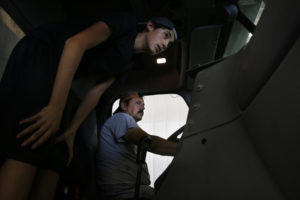 Angel visits his father, Juan, at work as he prepares machinery for the corn harvest. Elissa Nadworny/NPR