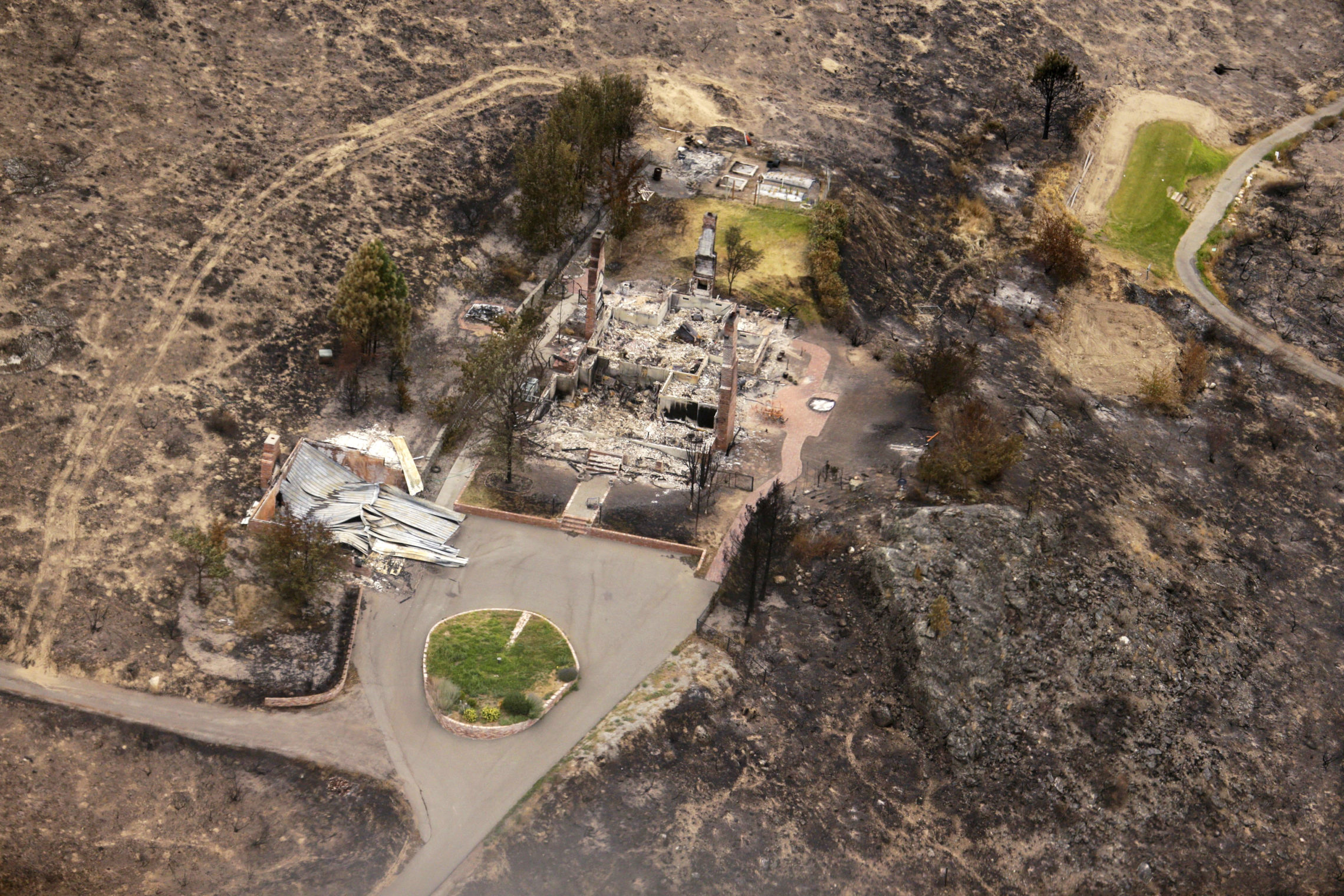 In this July 24, 2014, the remains of structures that were destroyed by wildfires near Pateros, Wash. The Carlton Complex fire was the largest in Washington State history. CREDIT: AP IMAGES/TED S. WARREN