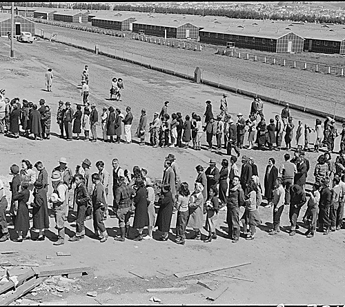 San Bruno, CA, 29 April 1942: This assembly center has been open for two days. Bus-load after bus-load of evacuated persons of Japanese ancestry are arriving on this day after going through the necessary procedures, they are guided to the quarters assigned to them in the barracks. CREDIT: DOROTHEA LANGE/WIKIMEDIA COMMONS