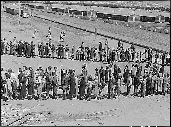 San Bruno, CA, 29 April 1942: This assembly center has been open for two days. Bus-load after bus-load of evacuated persons of Japanese ancestry are arriving on this day after going through the necessary procedures, they are guided to the quarters assigned to them in the barracks. CREDIT: DOROTHEA LANGE/WIKIMEDIA COMMONS