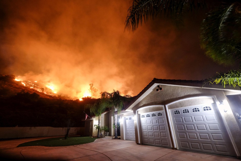 A wildfire burns near homes in the Cleveland National Forest in Lake Elsinore, California. CREDIT: RINGO H.W./AP