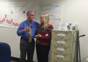 This photo shows former Employment Security Commissioner Dale Peinecke with his arm around Cathy Petrie during a meeting in January 2016. The image was later posted on the agency intranet and Petrie said it led to 