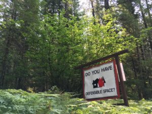 A roadside reminder in southwest Washington’s Gifford Pinchot National Forest that homes in the “wildlands urban interface” need special landscaping, building materials and maintenance to reduce the risk of being destroyed by a wildfire. CREDIT: CASSANDRA PROFITA /OPB