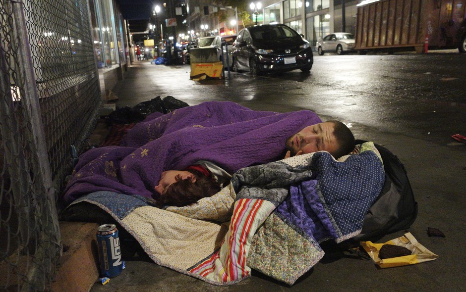 Taz Harrington, right, sleeps with his girlfriend, Melissa Ann Whitehead, on a street in downtown Portland, Oregon. CREDIT: TED S. WARREN/AP