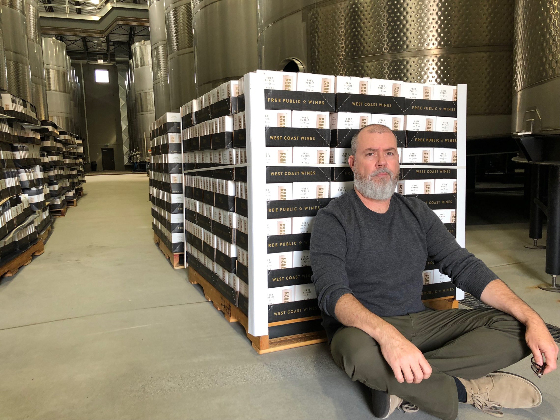 Michael Etter, president of Free Public wines, sits in front of a freshly canned pallet that’s ready to ship in Prosser, Wash. CREDIT: ANNA KING/N3