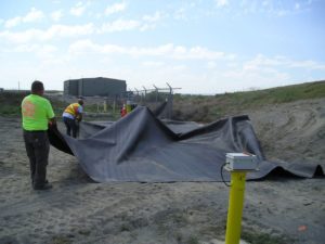 Contractors place an engineered cover, called geomembrane, over the balefill area at Pasco Sanitary Landfill. CREDIT: JOHN RICHARDS/WA DOE