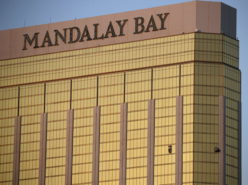 On Oct. 2, 2017, drapes billow out of broken windows at the Mandalay Bay resort on the Las Vegas Strip, following a deadly shooting at a music festival. On Tuesday, the company that owns the hotel offered to make a $500 charitable donation for victims who authorize their lawyers to accept legal notice of the company's lawsuit. CREDIT: JOHN LOCHER