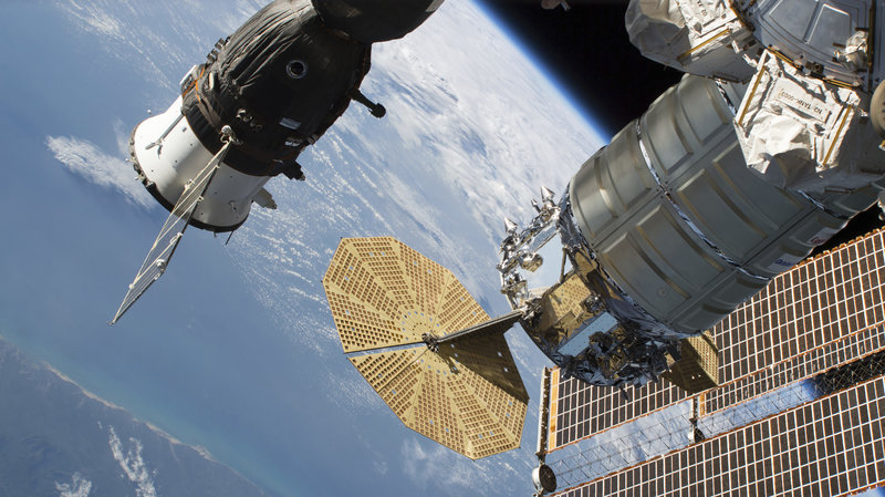 A 2-millimeter hole was found last week in a Russian Soyuz MS-09 spacecraft (left) that is docked to the International Space Station. CREDIT: NASA/AP