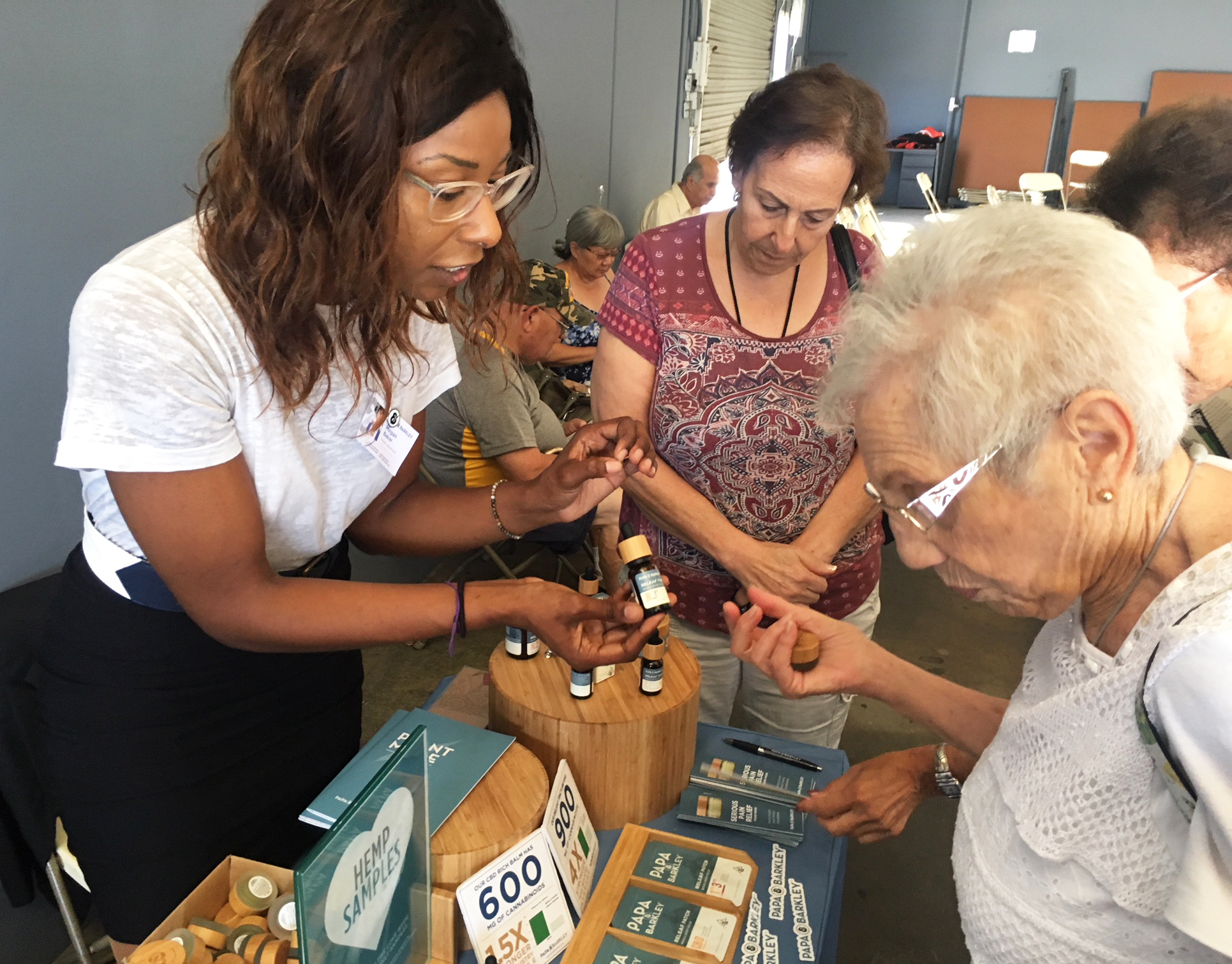 Megan Baker (left) of Papa & Barkley Co., a Cannabis company based in Eureka, Calif., shows Shirley Avedon of Laguna Woods different products intended to help with pain relief. CREDIT: STEPHANIE O'NEILL/NPR
