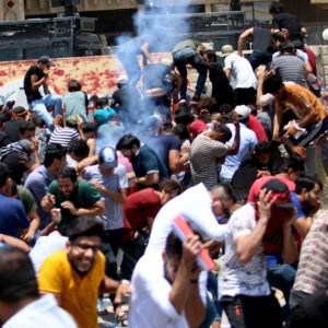 Protesters duck as Iraqi security forces fire tear gas during a demonstration against unemployment and a lack of basic services in Basra. Haidar CREDIT: Mohammed Ali/AFP/Getty Images