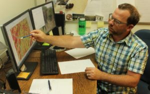 Oregon State University professor Chris Dunn examines a map of the likelihood of success for fire suppression in southern Oregon. Dunn is part of a Forest Service team using data to improve decision-making and risk assessment. CREDIT: TONY SCHICK