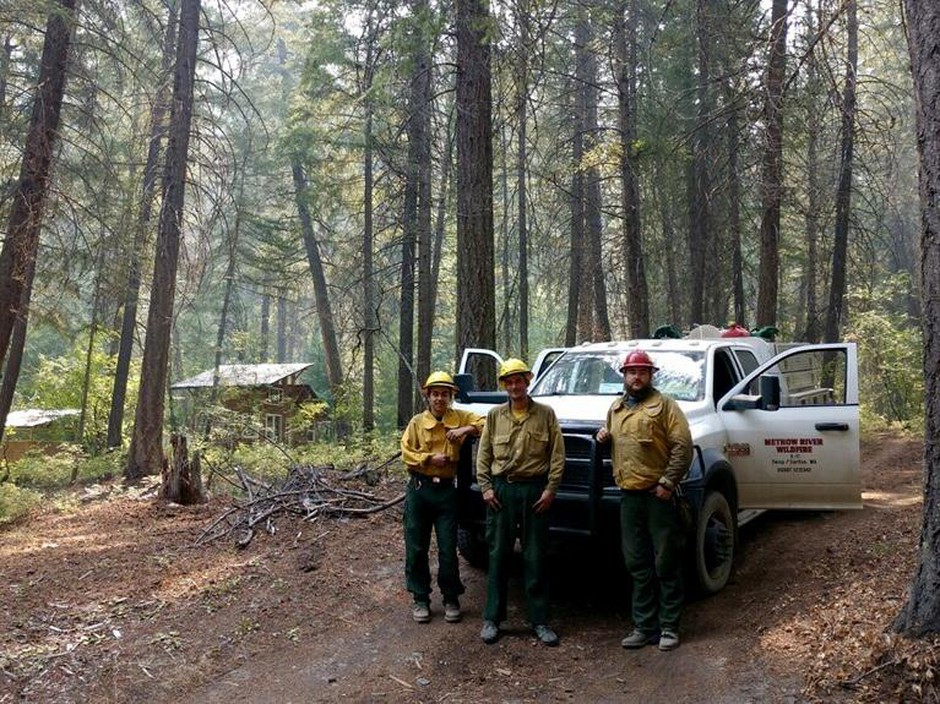 Firefighters with Methow River Wildfire worked to protect buildings during the Crescent Mountain Fire. Engine boss Steven Baltrusch (right) also works various jobs during the off season. Also pictured: Allen Dolph and Richie Harvey. CREDIT: BILL DUGUAY