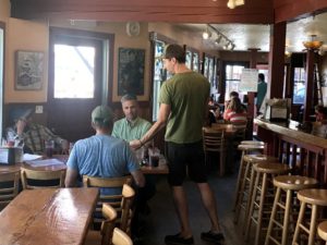 Old Schoolhouse Brewery owner Jacob Young serves food to his customers. He says when there's little smoke and fires are far away, he sees more patrons.CREDIT: COURTNEY FLATT