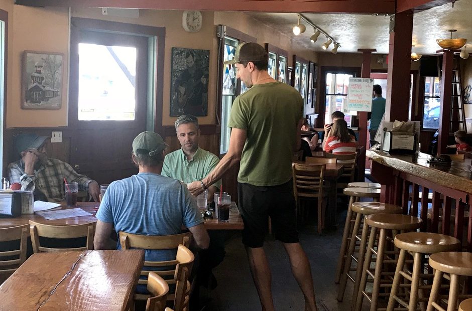 Old Schoolhouse Brewery owner Jacob Young serves food to his customers. He says when there's little smoke and fires are far away, he sees more patrons.CREDIT: COURTNEY FLATT