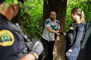 Social worker, Lauren Rainbow (right), meets a man illegally camped in the woods in Snohomish County. They are part of a new program in the county that helps people with addiction, instead of arresting them. CREDIT: Leah Nash for Finding Fixes Podcast