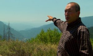 US Forest Service ecologist Frank Lake points out how wildfire smoke hangs in the Klamath and Salmon River valleys, lowering the water temperature for the salmon. CREDIT: NICK FISHER