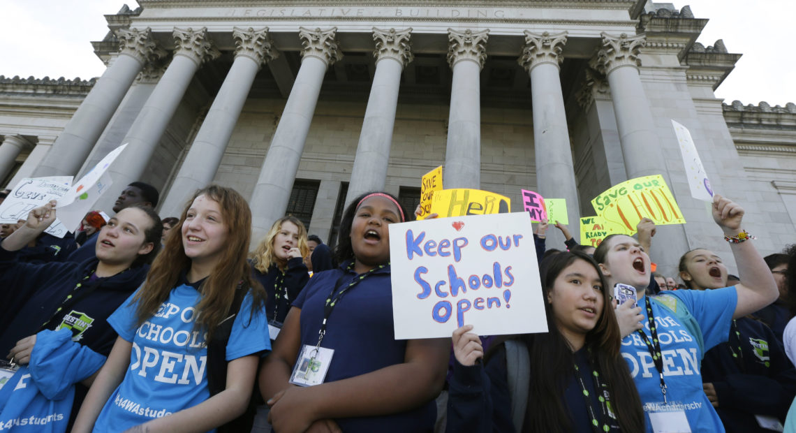 children hold signs during a rally in support of charter schools at the Capitol in Olympia . CREDIT: AP Photo/Ted S. Warren, File