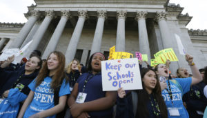 children hold signs during a rally in support of charter schools at the Capitol in Olympia . CREDIT: AP Photo/Ted S. Warren, File