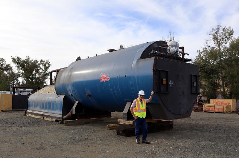 Biomass Operations Specialist John Rowell stands next to a boiler that awaits installation pending permits. TOM BANSE / NW NEWS NETWORK